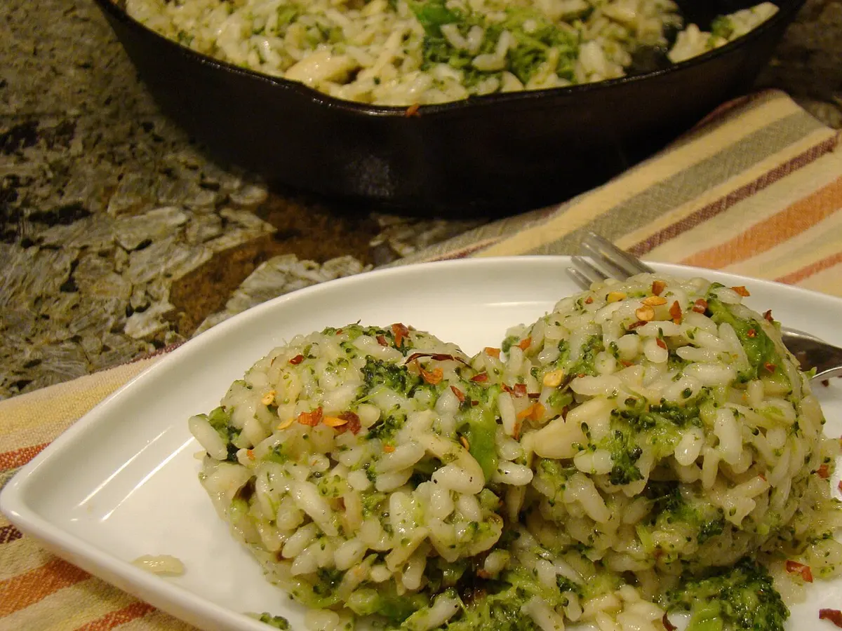 Porções de arroz com brócolis servidas num prato branco