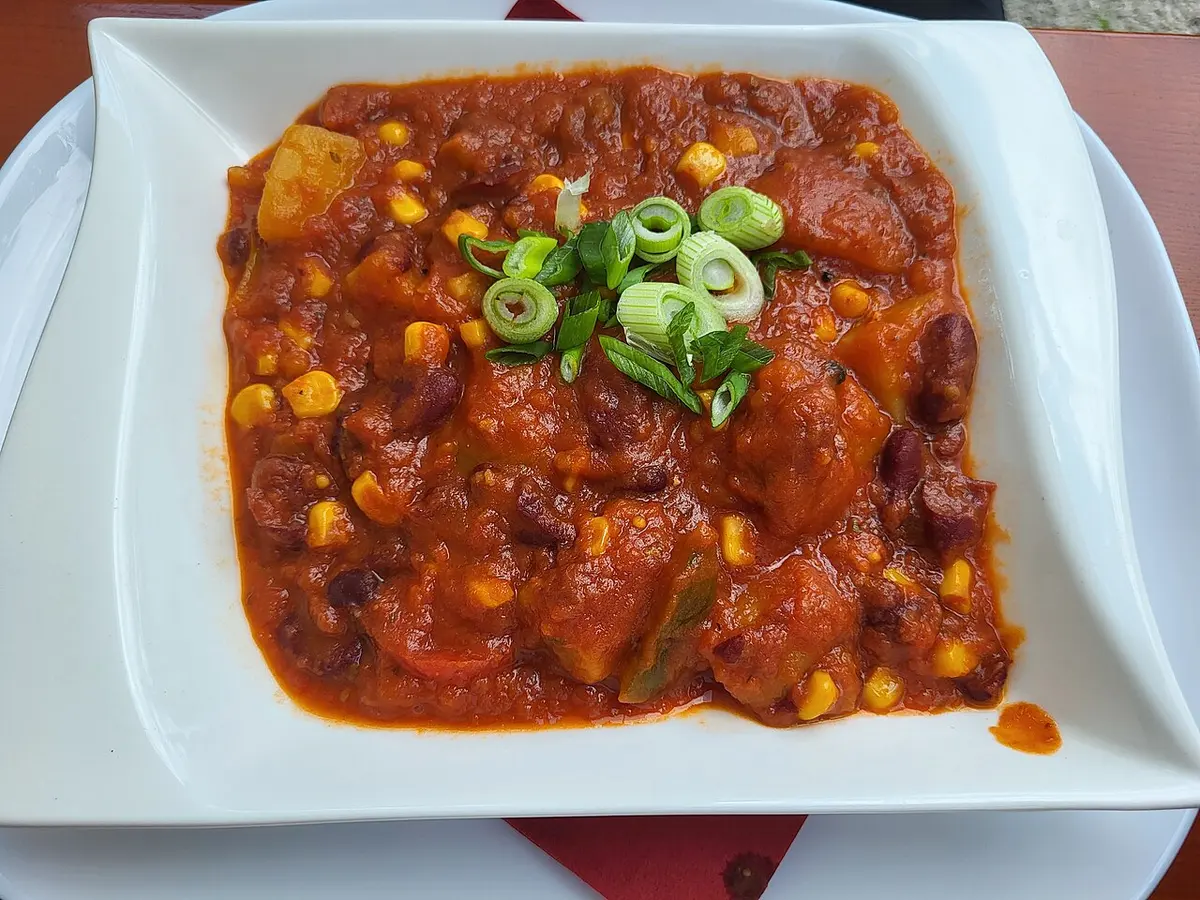 Ensopado de feijão-vermelho com tomate, milho e pimentão, finalizado com cebolinha