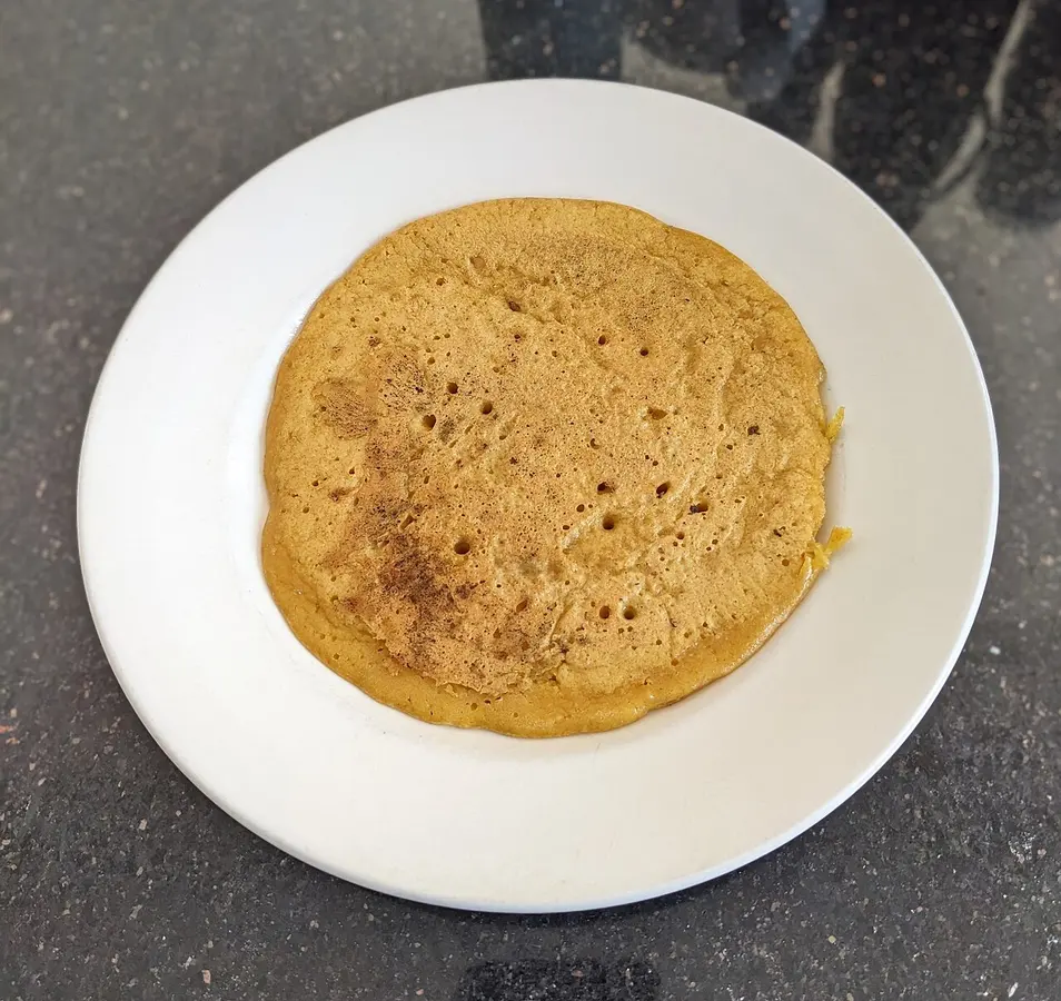 Panqueca dourada de farinha de grão-de-bico servida num prato branco