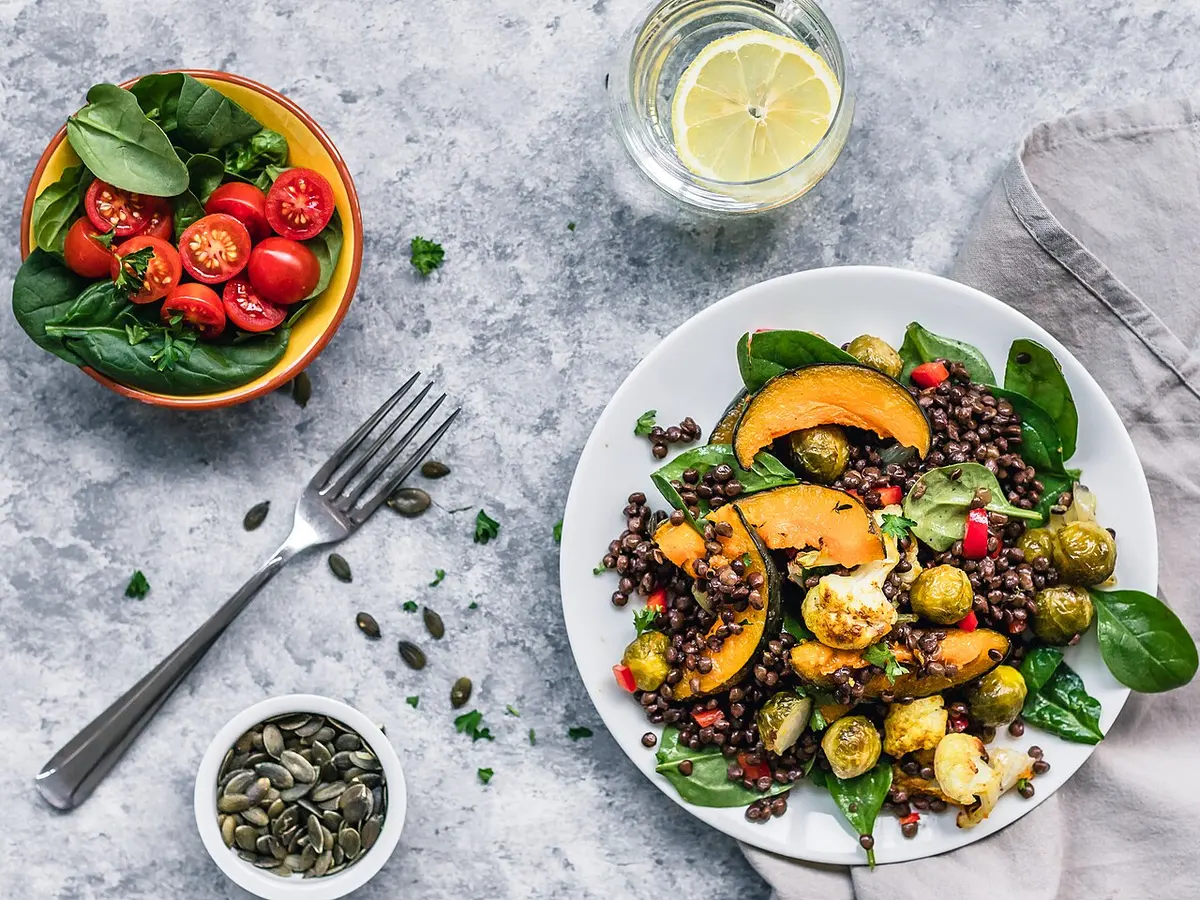 Prato de salada de lentilha com abóbora assada, couve-de-bruxelas e folhas verdes
