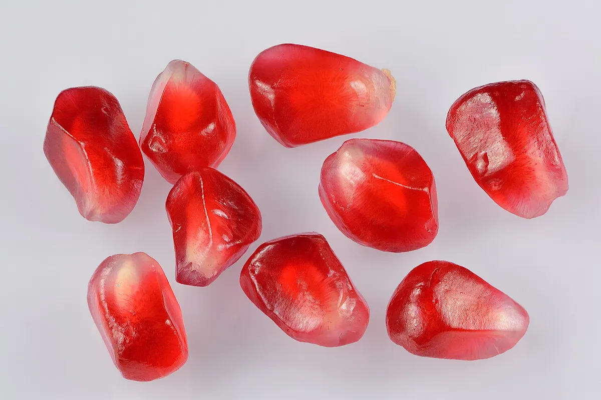 Romãs maduras com a casca vermelha e uma romã aberta mostrando as sementes